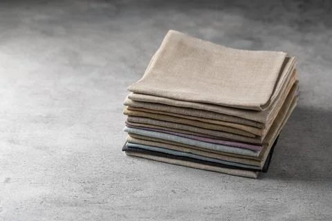 A pile of four folded dull-colored natural linen fabric Stock Photos