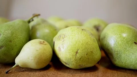 Pile of fresh green pears lying on a wooden surface in slow motion Stock Footage 330118185