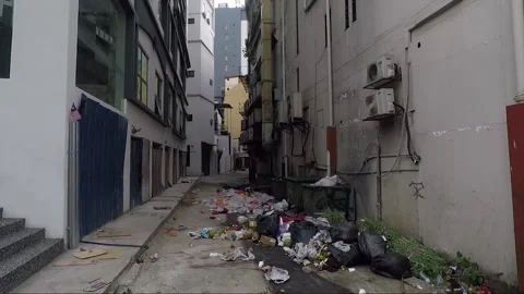 Pile of garbage between buildings on narrow side street, Kuala Lumpur, Malaysia Stock Footage 169386574