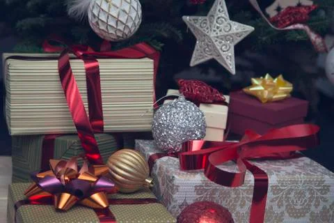A pile of gift boxes under a decorated Christmas tree Stock Photos