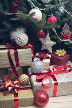 A pile of gift boxes under a decorated Christmas tree Stock Photos