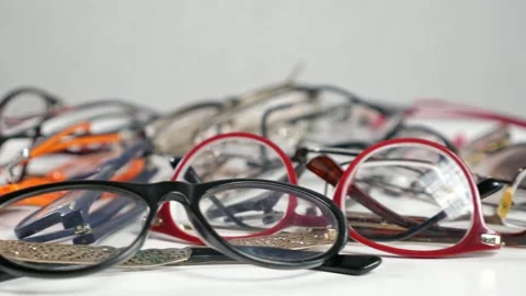 Pile of glasses with colored frames lies on wooden table Stock Footage 162455189