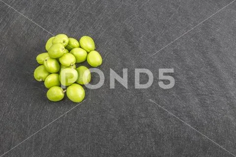 Pile of green apricots lay on black background Stock Photos