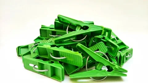 A pile of green laundry clips rotating on the white background, plastic clips Stock Footage 306038827