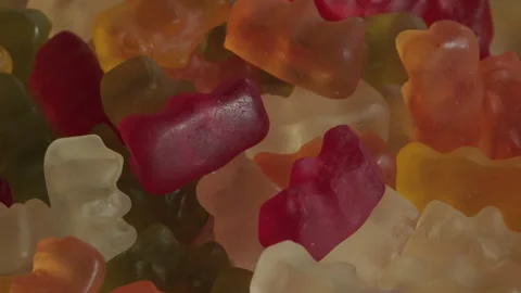 Pile of gummy bear candy background rotating macro. Unhealthy food concept Stock Footage 283875812