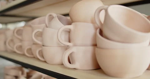 A pile of hand made ceramic dishes lying on a rack in a pottery workshop. Video stock 154356991