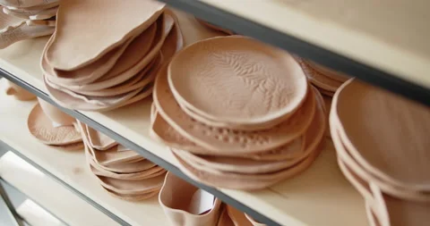 A pile of hand made ceramic dishes lying on a rack in a pottery workshop. Video stock 154357112
