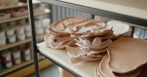 A pile of hand made ceramic dishes lying on a rack in a pottery workshop. Video stock 154357162