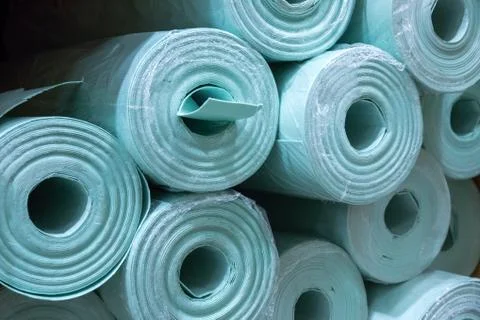Pile of insulation material rolls. Light green or blue color. Filled frame. Stock Photos