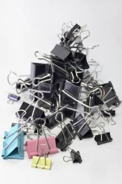 Pile of metal binder clips for paper. different sizes and colors. vertical Stock Photos