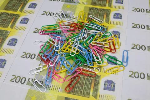 A pile of multi-colored paper clips lies on 200 Euro banknotes Stock-Fotos