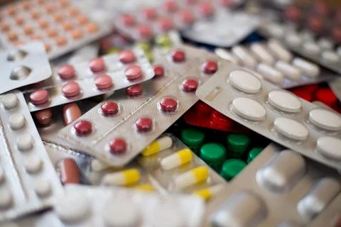 A pile of multi-colored pills lie one on one Stock Photos