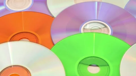 Pile of multicolored CDs and DVDs on the table, tracking shot Stock Footage 267194054