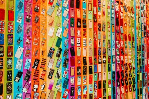 Pile of multicolored plastic back covers for mobile phones in shop. Choice of Stock Photos