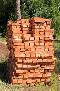 A pile of new red bricks at construction site sitting on wooden flat. A pi... Stock Photos