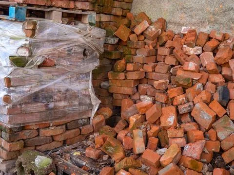 Pile of old red bricks. Forgotten building material. A pile of stones. Unfi.. Stock Photos