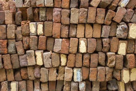 A pile of old red bricks stacked in even rows. rough surface texture Stock Photos