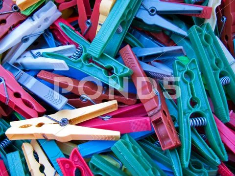 Pile of old, used multicoloured clothes pegs Stock Photos