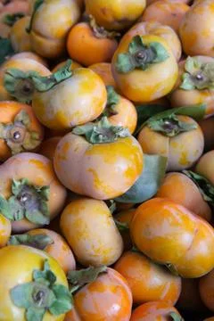 Pile of orange persimmons Stock Photos