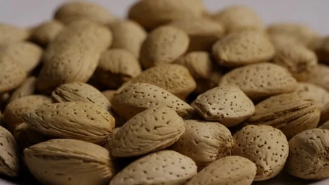 Pile of organic almonds in shells rotating slowly around Stock Footage 327829351