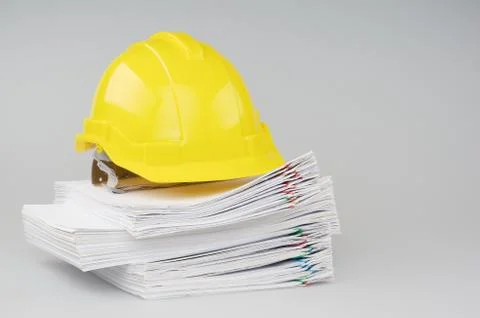 Pile overload document have yellow engineer hat on top Stock Photos