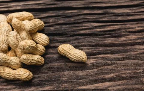 Pile of peanuts, peanuts stack on wooden table with copy space. Stock Photos
