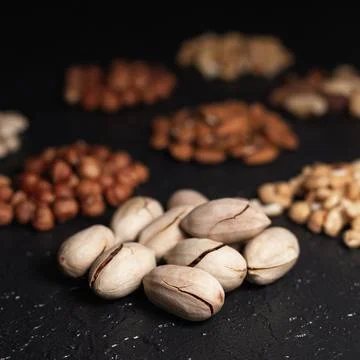 Pile of pecans in shell on black table 스톡 사진