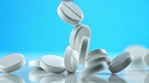 Pile of pills fall on the table. Filmed is slow motion 1000 frames per second. Video stock 271276947