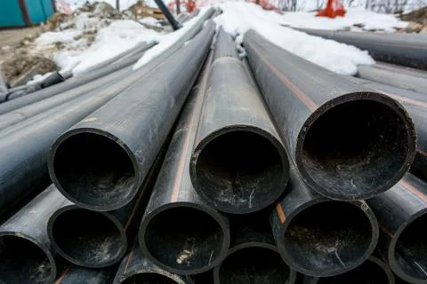 Pile of plastic pipes on construction site ready to be used. Stock Photos