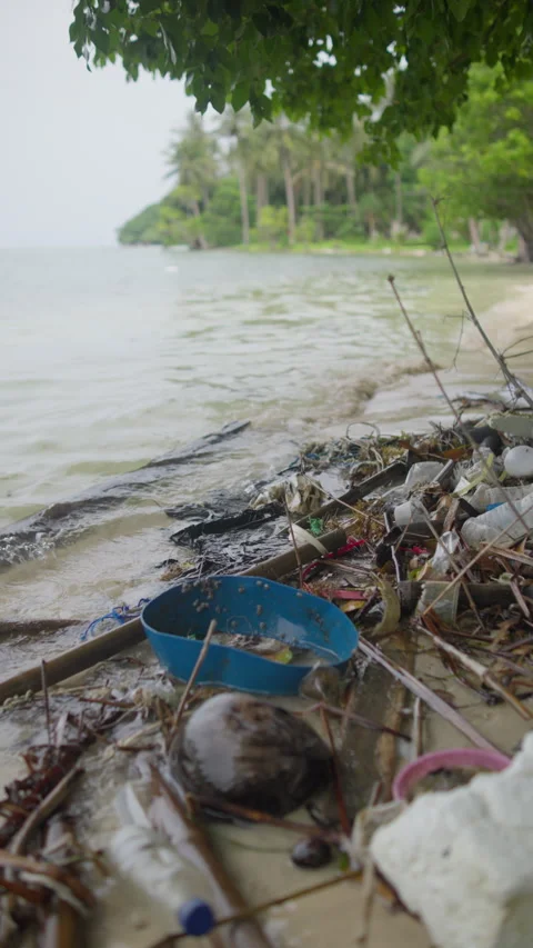 Pile of plastic waste and discarded garbage polluting a sandy beach Stock Footage 344604822