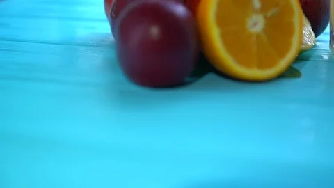 Pile of plums and citrus fruit next to two glasses Stock Footage 94037814