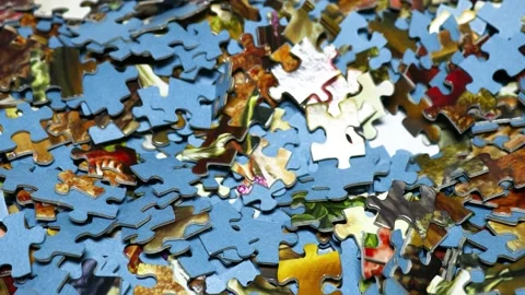 A pile of puzzle pieces sitting on a table, ready to be assembled Stock Footage 345168685