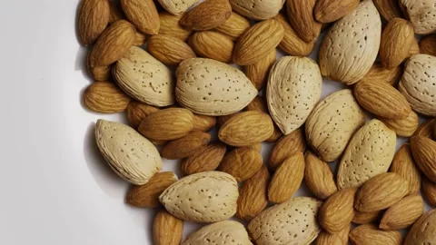 Pile of raw almonds in shells on white surface. Stock Footage 327948417