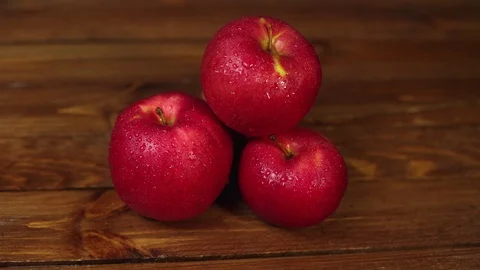 A pile of red appetizing apples on a dark wooden table. Stock Footage 102449261