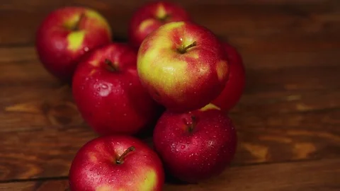 A pile of red appetizing apples on a dark wooden table. Stock Footage 103260267