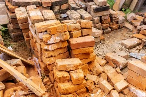 Pile of red bricks at a construction site in the city. Repair, industrial bri Stock Photos
