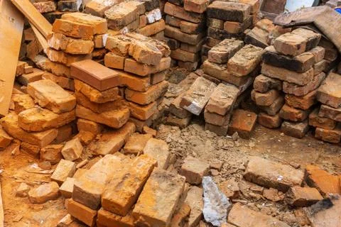 Pile of red bricks at a construction site in the city. Repair, industrial bri Stock Photos