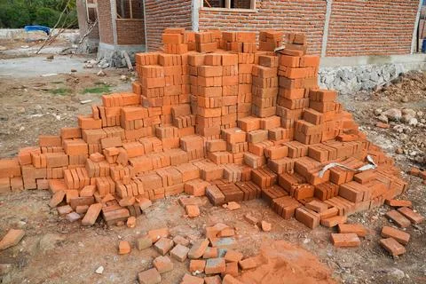 Pile of red bricks on a construction site. brick stacked background texture Stock Photos