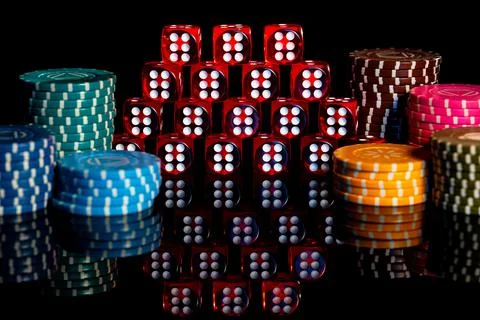 Pile of red dice and stack of casino chips on isolated black background. Pyramid Stock Photos