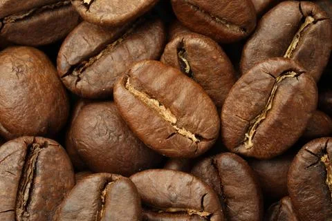Pile of roasted coffee beans as background, closeup Stockfoto's