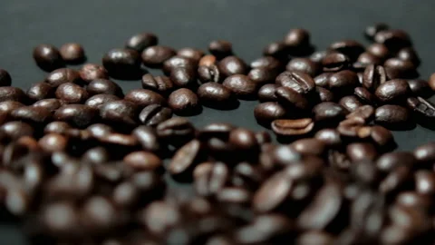 Pile of roasted coffee beans moving on black surface Stock Footage 162514396