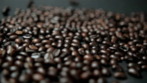 Pile of roasted coffee beans moving on black surface Stock Footage 162563344