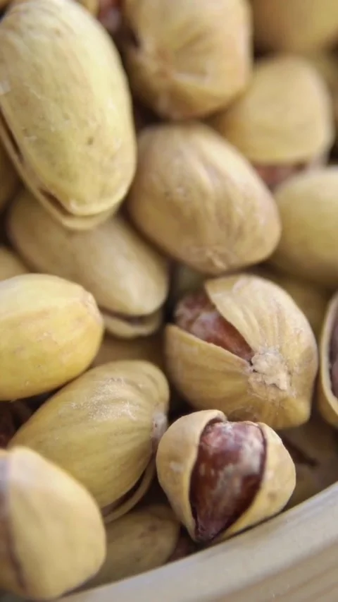 Pile of roasted salted pistachios in shells rotating slowly Stock Footage 334169641