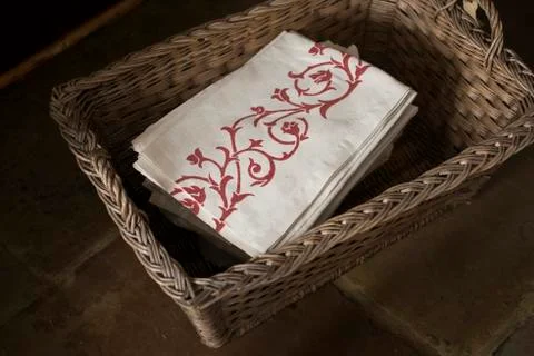 Pile of Rose-Patterned Napkins in a Rectangular Woven Basket Stock Photos
