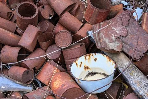 A pile of rusty cans and a white bowl Stock Photos