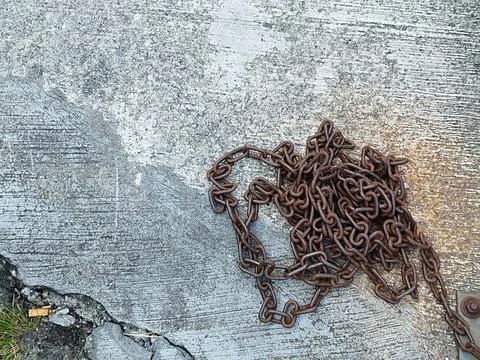 Pile of rusty iron chains on cement floor Stock-Fotos