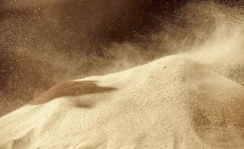 Pile of sand explosion, Sandy fly wave over dark background. Stock Photos