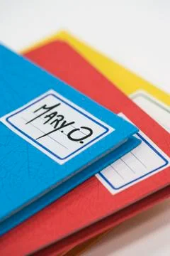 Pile of school notebooks with name written on label Stock Photos