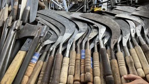A pile of sharp tools such as knives, machetes, axes, sickles, metal sickles Stock-Fotos
