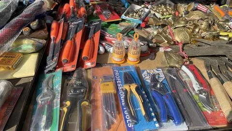 A pile of sharp tools such as knives, machetes, axes, sickles, metal sickles Stock Photos